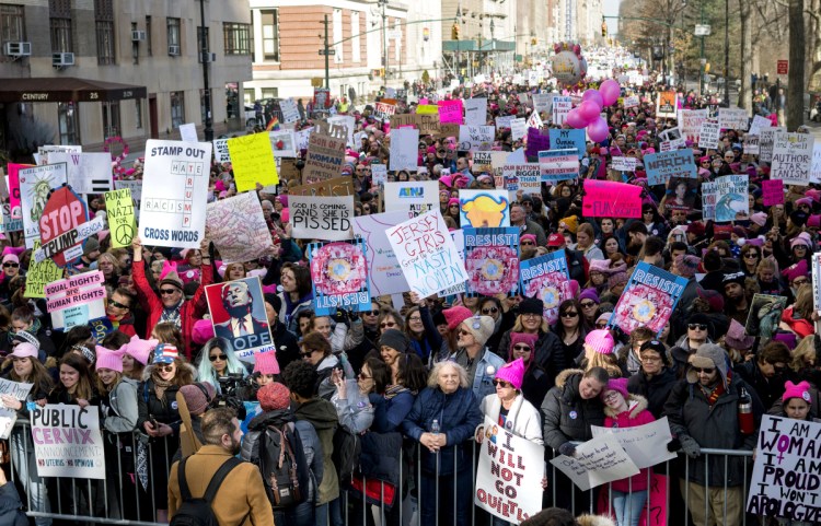 People line up on Central Park West as they wait for the start of a march highlighting equal rights and equality for women Saturday in New York. The New York protest was among more than 200 such actions planned for the weekend around the world.