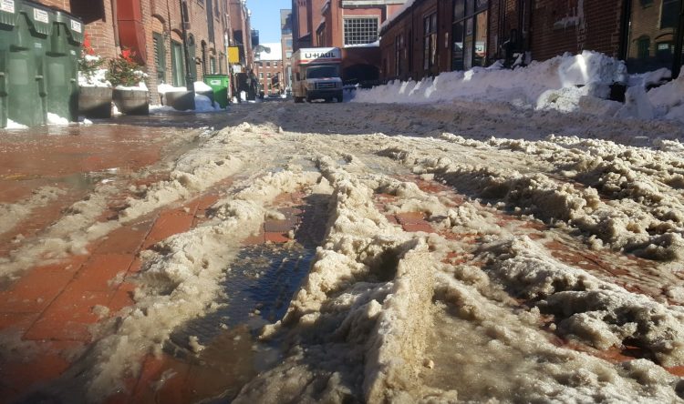 Wharf Street turns into a soupy mixture Tuesday as temperatures in Portland hover near 40 degrees.  