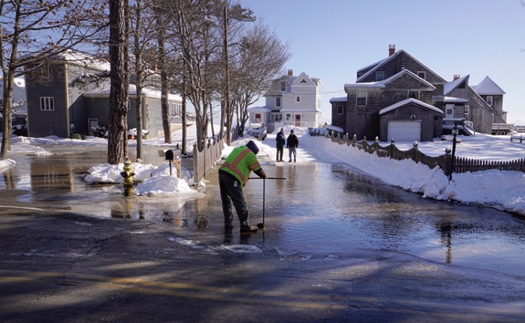 Kirk Ladakakos of Maine Water closes a valve along East Grand Avenue in Scarborough, where a water main broke because of the cold weather on New Year's Day. The break left about 100 customers without water but workers estimated that they would have service restored by Monday evening.