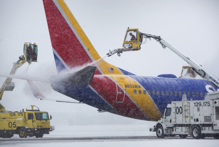 De-icing trucks work on Southwest Airlines flight 544 at the Portland International Jetport on Jan. 17, before its departure for Baltimore.