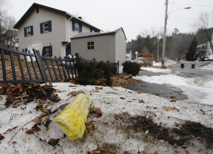 A plastic-wrapped newspaper lies uncollected in an Acorn Street yard in Biddeford. A regional group that advocates for freedom of the press has called on the city to alter rules it established late last year.