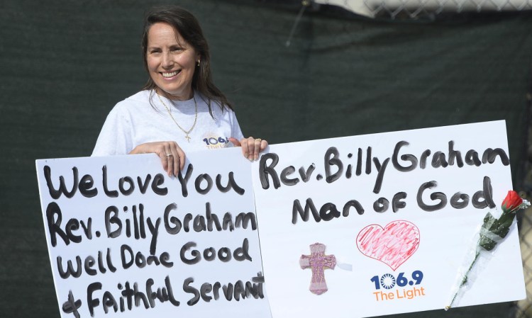 Rose Salazar of Cornelius, N.C., waits for the motorcade carrying the body of the late Rev. Billy Graham to proceed through uptown Charlotte, N.C. on Saturday.