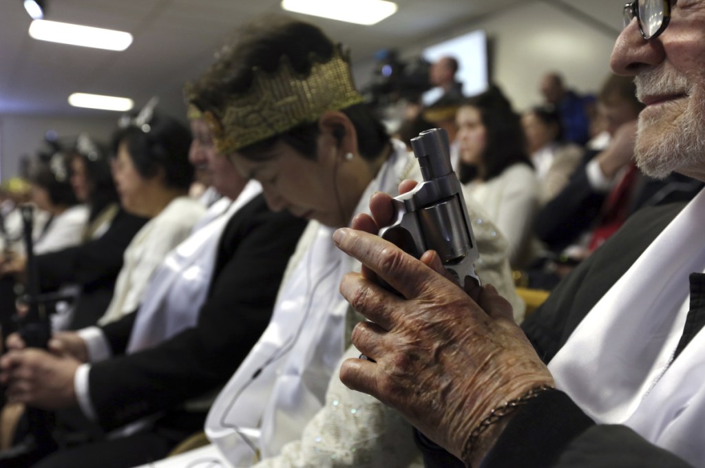 A man holds an unloaded weapon on Wednesday at the World Peace and Unification Sanctuary in Newfoundland, Pa.