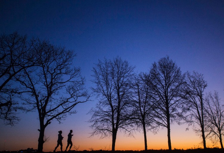 A pair of joggers circle Back Cove in Portland just after sunset on Wednesday, November 28, 2018. (Staff photo by Derek Davis/Staff Photographer