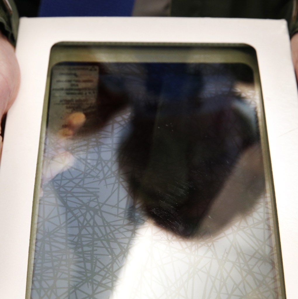 Alan Thibeault, the University of New England's assistant vice president of planning, displays a pane of bird-proof glass in this contrast-enhanced photo. The criss-cross patterns are visible to humans only when viewed at an extreme angle, but are clearly visible to birds at all angles.