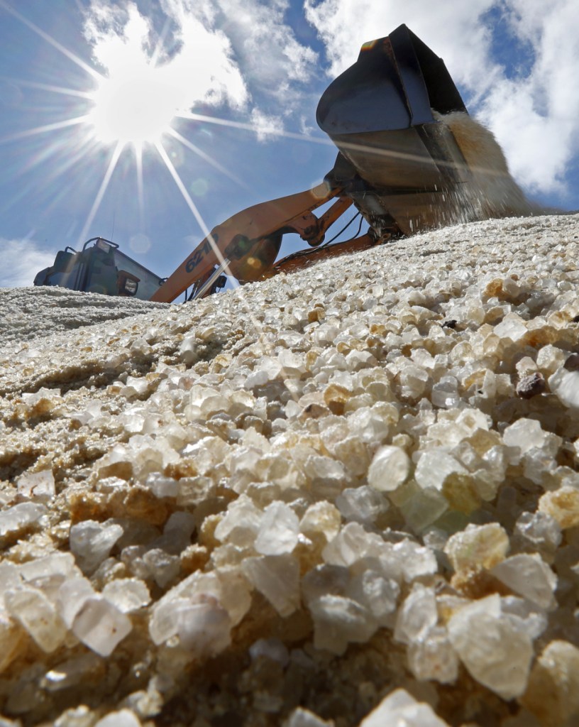 Road salt is mixed by a front-end loader before being loaded onto public works trucks Monday in Freeport.