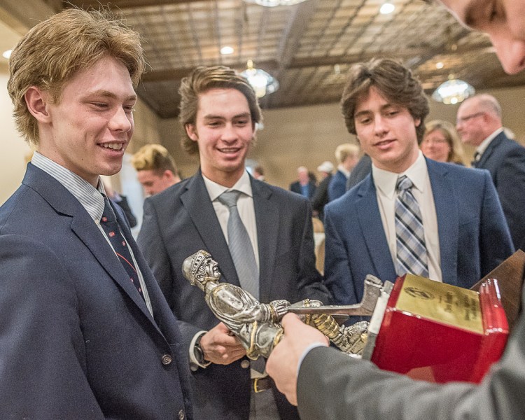 Theo Hembre, left, shows off the Travis Roy Award to Falmouth teammates Marcus Cady and Louis Mainella after the awards banquet Sunday at the Ramada Inn in Lewiston.