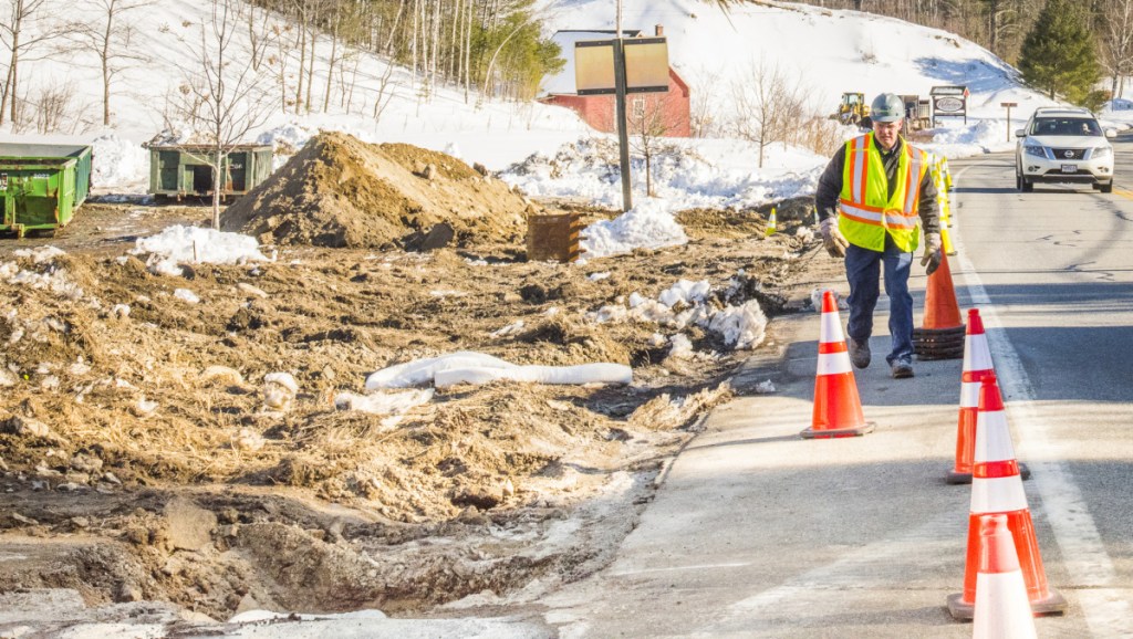 A worker from Enviro lines up traffic cones along Route 27 in Belgrade on Monday after a gasoline spill around Christy's Country Store in Belgrade.