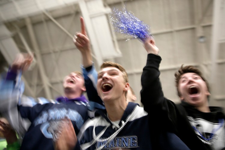 Chris Albert, center, a sophomore at Old Town High School, celebrates with classmates after Old Town/Orono beat Greely, 3-2, in overtime in the Class B state championship hockey game in Lewiston on March 10.  