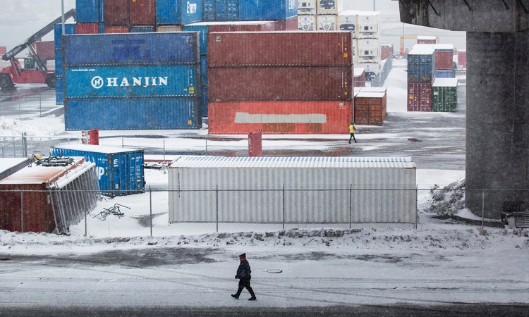  A man walks under the Casco Bay Bridge on Thursday, March 22, 2018, as light snow falls in Portland. 