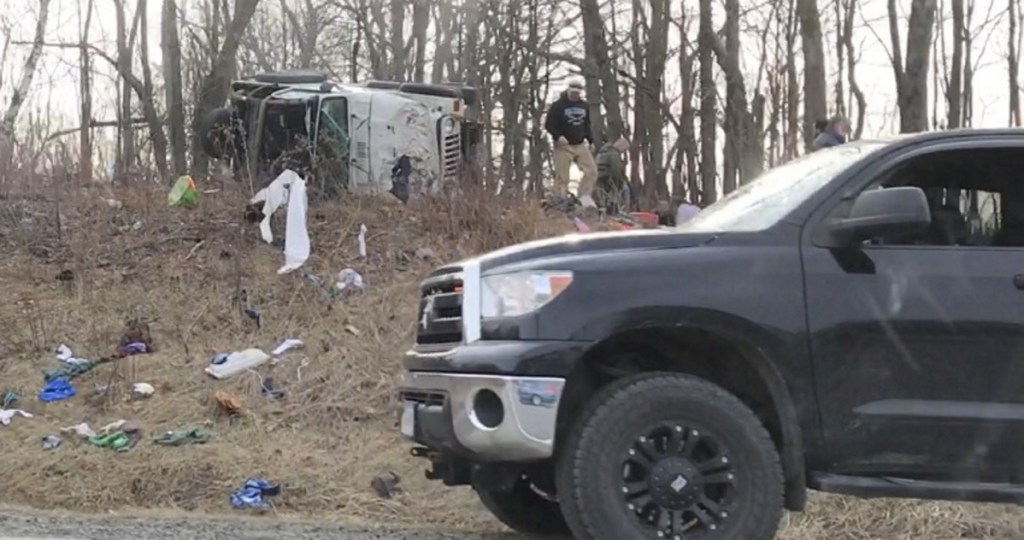 A sport utility vehicle lies on its side Tuesday morning up a hill from Interstate 95 in Farmingdale after a crash on the highway.