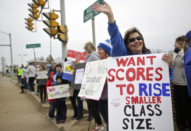 Sapulpa Middle School teacher Vina Janitz and others protest in front of Sapulpa High School in Tulsa, Okla., on day 4 of the teacher walkout Thursday. Thousands of teachers, students and their supporters have thronged the Capitol for four straight days seeking more funding for schools.