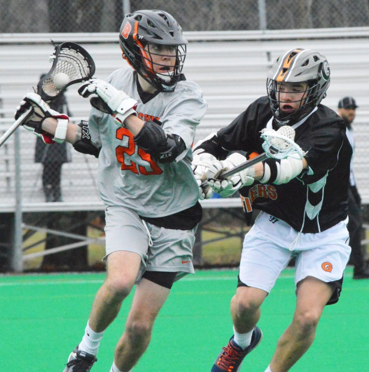 Brunswick's Jacob Belanger carries the ball with Shawn Michaud of Gardiner defending Tuesday at Bowdoin College. The Dragons improved to 2-0 with a 20-8 win.