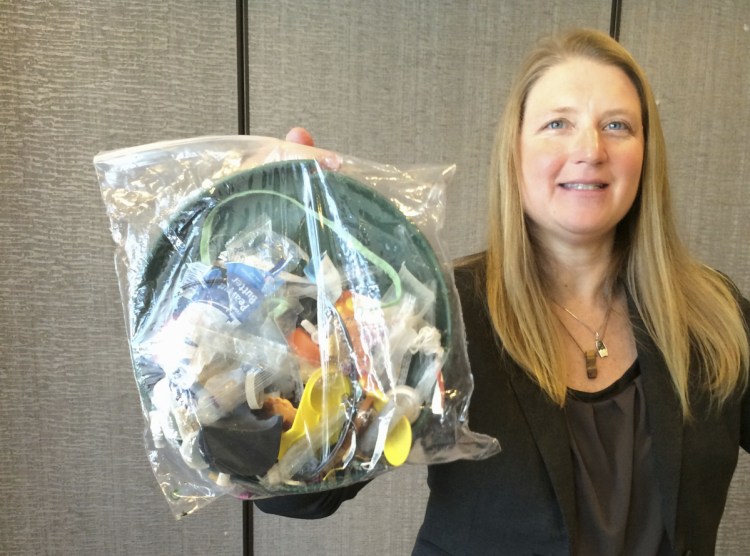 Jenna Jambeck, an environment engineering professor at the University of Georgia, holds a bag of trash collected last fall from a cleanup at Panama Beach, Fla. 