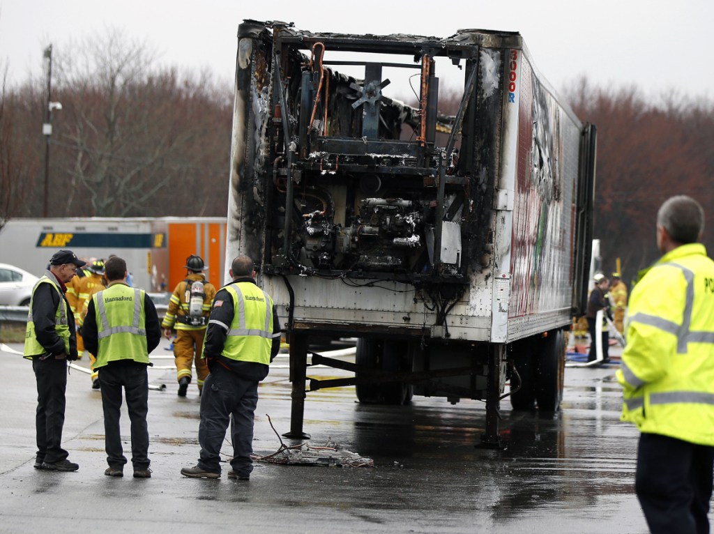 Hannaford workers and emergency responders gather near a refrigerated trailer that caught fire Thursday morning at a Hannaford warehouse in South Portland.