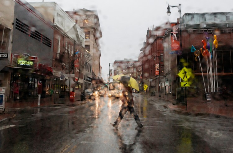 A man crosses Congress Street on a rainy Wednesday afternoon in downtown Portland. 