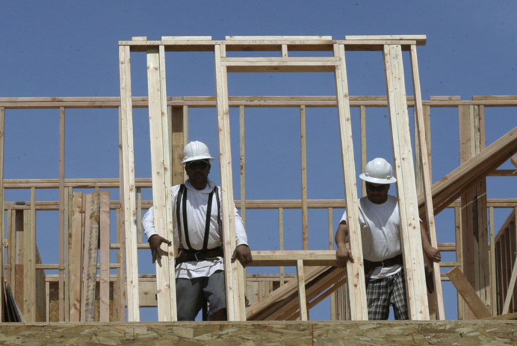 Workers raise a frame on a house under construction Friday near Roseville, Calif. The long-simmering economic expansion in the U.S. has been frustrating to some because it hasn't come with a commensurate growth in pay. Now, with unemployment at its lowest rate since December 2000, some analysts expect that dynamic to change.