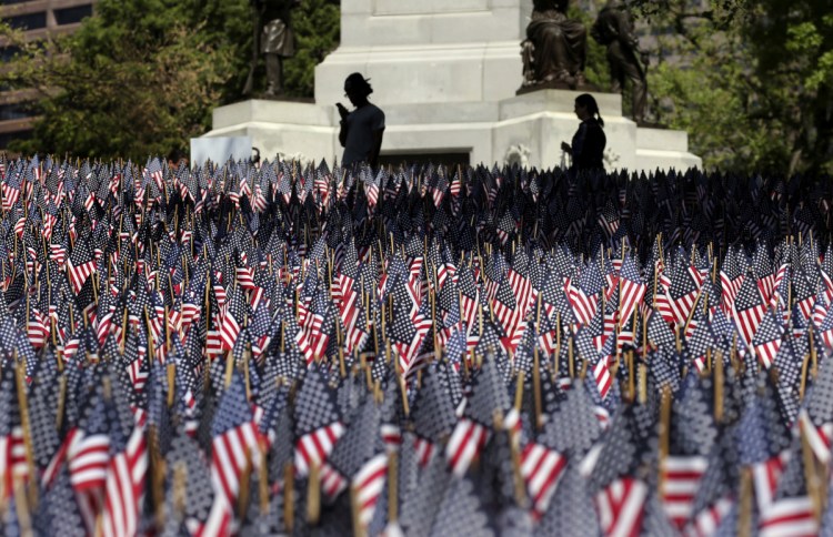 People view flags placed on Boston Common.