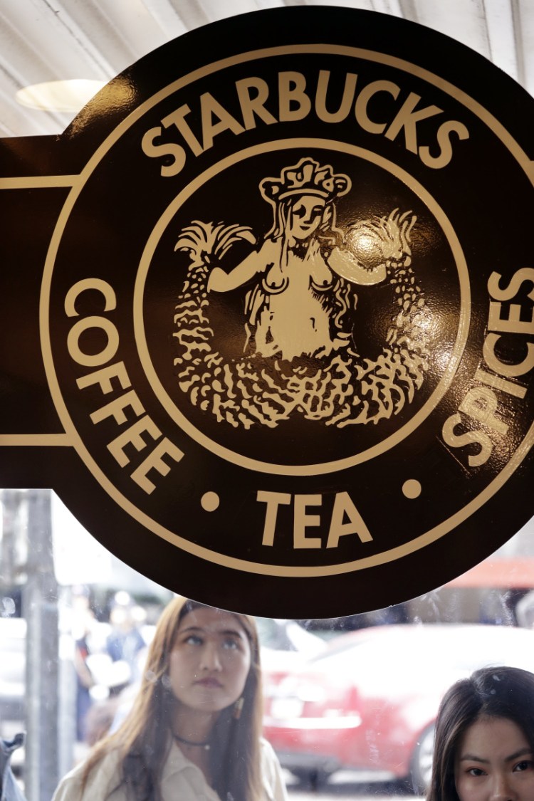 Visitors peer inside the 'original' Starbucks in Seattle shortly before it closed for bias training on Tuesday.