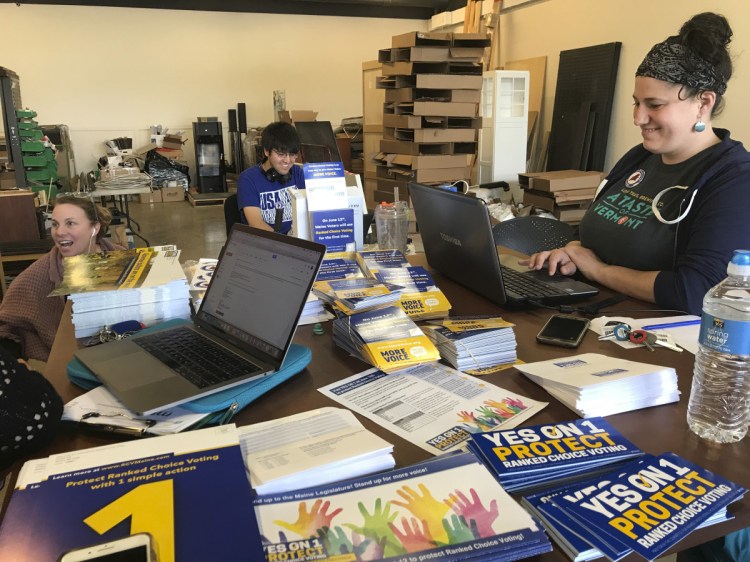 Staff members for the Committee for Ranked Choice Voting, Abbie Ryder, right, Cormack Manning, middle, and Cara McCormick, left, work Friday at getting people to turn out to vote in support of the ballot question. Question 1 on Tuesday's ballot will decide whether Mainers continue to use ranked-choice voting in future elections.