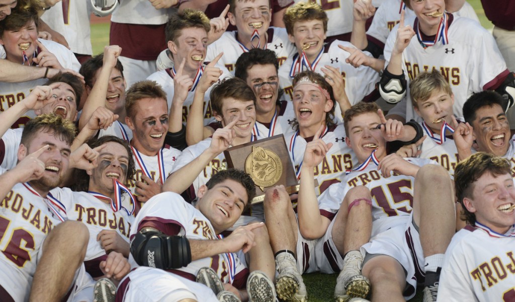 Thornton Academy celebrates with the trophy after its victory in the Class A state championship game Saturday night at Fitzpatrick Stadium in Portland.