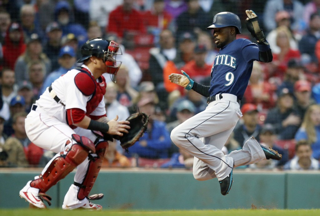 Seattle's Dee Gordon scores on a double by Mitch Haniger as Red Sox catcher Christian Vazquez waits for the throw in the first inning Saturday night at Fenway Park. Haniger drove in three runs in a 7-2 victory.
