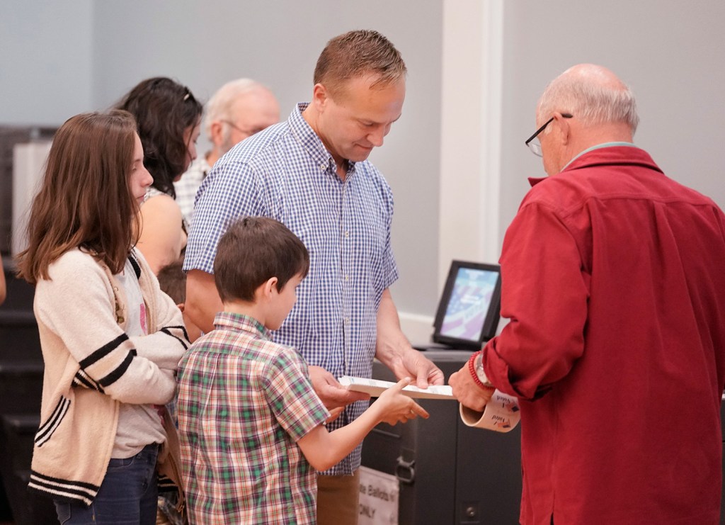 Democratic gubernatorial candidate Adam Cote gets help recording his ballot from his youngest son, Michael, while voting in Springvale on Tuesday. 