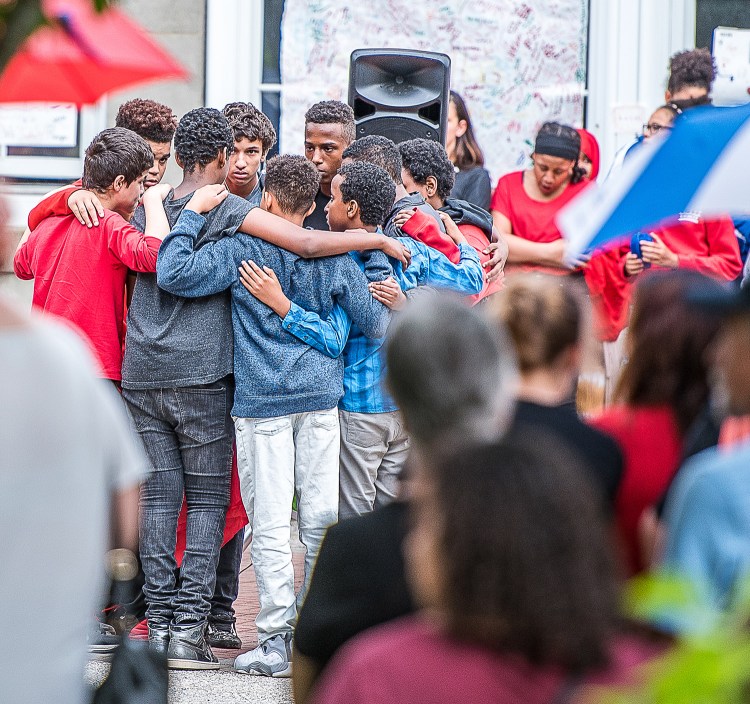 Nine of Rayan Issa's friends form a tight circle at the center of a vigil at Lewiston Middle School on Wednesday night. Rayan apparently drowned during a school trip to Range Pond in Poland on Tuesday.