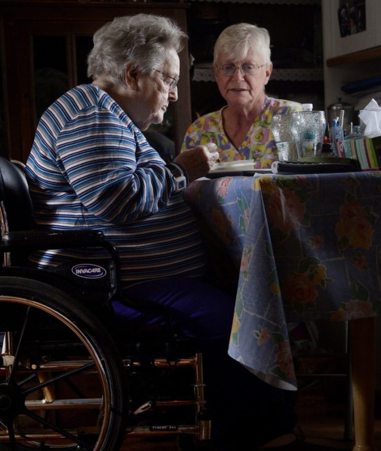 Nancy Boily, 65, a personal care attendant, sits with Mildred Rood, 85, during a 2014 home care visit to Rood's Windsor home. A reader urges Mainers to vote yes on Question 1, Homecare for All.