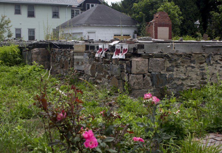 Red hearts are still displayed on the foundation of the duplex at 20-24 Noyes St. that burned on Nov. 1, 2014, leading to the deaths of six people.