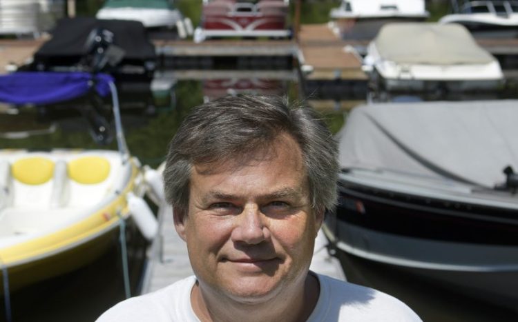 Shawn Grant stands Monday on the docks at Brightside Marina, the business he owns in Belgrade Lakes Village. Grant is appealing the denial of a commercial business permit for the marina he has operated on Hulin Road for 10 years.