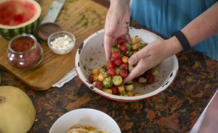 Christine Burns Rudalevige mixes up the melon, chili flakes, cilantro, mint and dressing for Chilled Melon and Chili Salad.