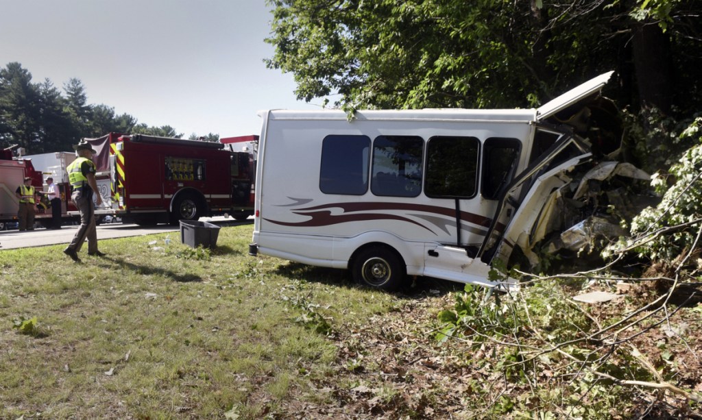 New Hampshire State Police inspect a van involved in an accident Friday on Interstate 95 in Greenland, N.H. Children with a Kittery Recreation Department program were among those injured when the van crashed in a wooded area. One was taken to a Boston hospital with serious injuries.