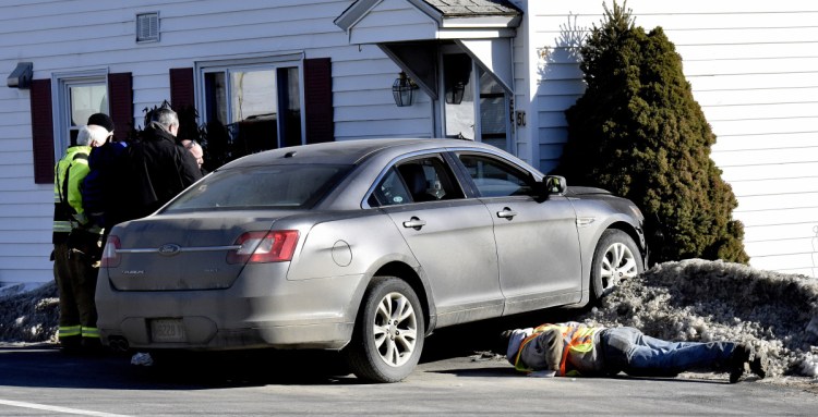 A tow truck operator looks under a vehicle that struck 50 Halifax St. in Winslow on Jan. 31. The driver was fined and sentenced to jail time, license suspension and probation on Thursday.