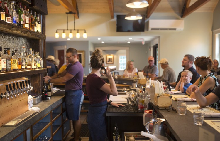 Brittney Andrews shakes up a cocktail behind the bar.