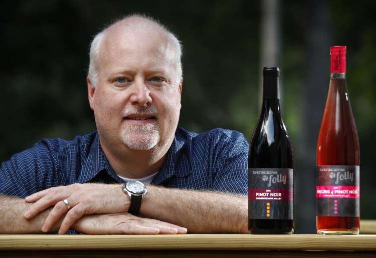 Kirk Duke, whose family runs a California winery, shows some bottles of wine at his home in Falmouth. Duke University had blocked the company from registering the trademark Duke's Folly, saying it "deceptively" implied a tie to the North Carolina university. The family's response? That's "absurd."