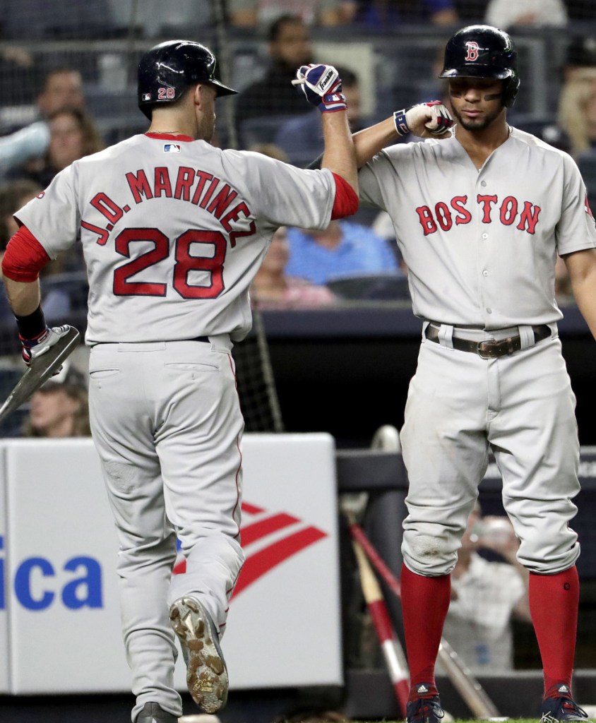 Boston's J.D. Martinez  bumps forearms with Xander Bogaerts after his sacrifice fly drove in Ian Kinsler in the third inning of Tuesday's 3-2 loss to the Yankees in New York.