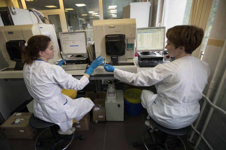 FILE - In this May 24, 2016 file photo employees work in Russia's national drug-testing laboratory in Moscow. Russian doping whistleblower Grigory Rodchenkov, the whistleblower who exposed Russia's doping corruption at the Sochi Olympics added to a chorus of protest over the possible reinstatement of the country's anti-doping agency. In a statement provided to The Associated Press, Grigory Rodchenkov portrayed the World Anti-Doping Agency's shifting of its requirements to end RUSADA's suspension as a result of Russia's unwillingness to accept findings from investigator Richard McLaren, who detailed a government-sponsored doping program designed to win medals. (AP Photo/Alexander Zemlianichenko, File)