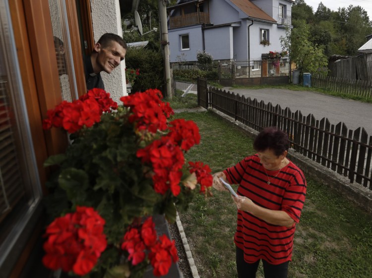 The Rev. Michal Lajcha hands out his book "The Tragedy of Celibacy – The Death of Wife," in Klak, Slovakia. Lajcha is challenging the Roman Catholic Church's celibacy rules in a rare instance of dissent in the conservative religious stronghold in central and eastern Europe.