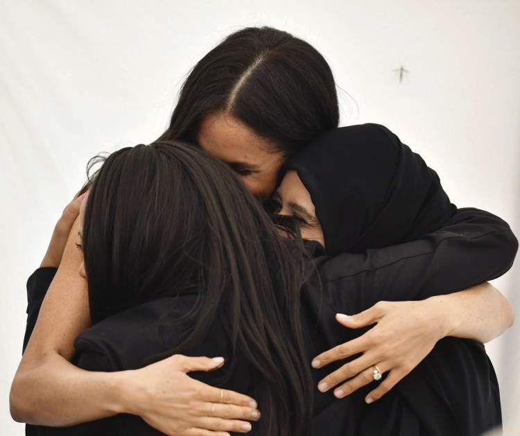 The Duchess of Sussex embraces women at the launch of the cookbook "Together" in London last week. The book's sales will help victims of the 2017 Grenfell Tower fire.