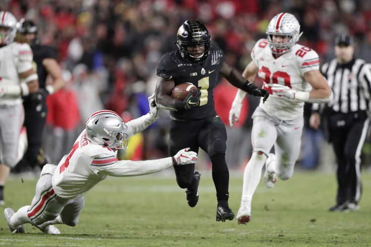 Purdue running back D.J. Knox cuts between Ohio State safety Jordan Fuller (4) and linebacker Pete Werner on his way to a touchdown Saturday.