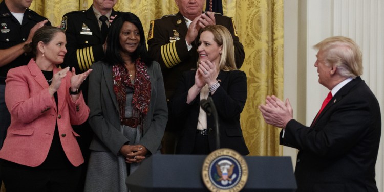 DeeDee Wheeler, a recovering addict who has been clean for over three years, is cheered by President Trump Wednesday in the East Room of the White House. Nearly 48,000 people died last year from opioid overdoses.