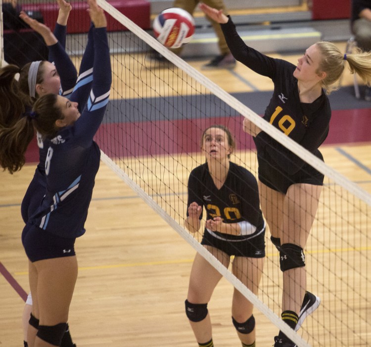 Cape Elizabeth's Bridget Heggie, right, goes up for a kill against York's Emma Parrotta, front, and Abby Orso during their Class B volleyball semifinal Wednesday night. The top-ranked Capers won 25-14, 25-16, 25-6.