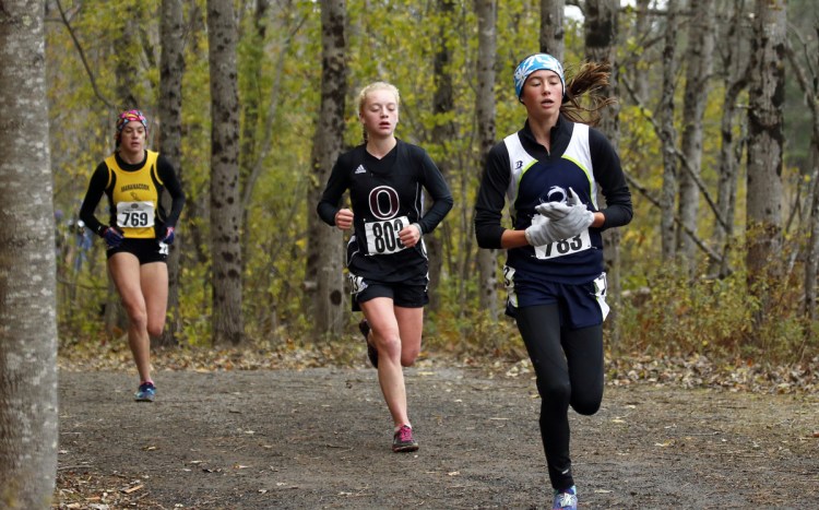 Maine Coast Waldorf's Olivia Reynolds, right, the eventual winner of the Class C cross country championships, maintains a tight lead into the backstretch at Troy A. Howard Middle School on Saturday. At her heels is Orono's Erin Gerbi, center, and Maranacook's Molly McGrail. (Staff photo by Ben McCanna/Staff Photographer)