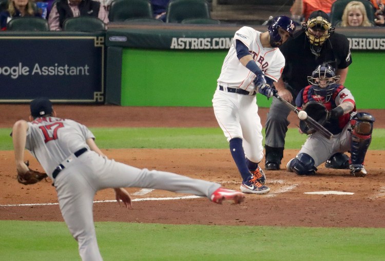 Houston Astros' Marwin Gonzalez hits a RBI-single against the Boston Red Sox during the first inning in Game 3 of a baseball American League Championship Series on Tuesday in Houston. Major League Baseball acknowledged Tuesday that it had investigated an incident three nights earlier, in which an Astros employee was spotted in the camera well adjacent to the Boston Red Sox dugout at Fenway Park and reportedly aiming a camera into the dugout.