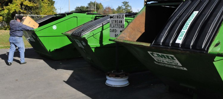 John Perry deposits recyclable material in a bin at the Winslow Public Library last month. The town's recycling protocol is about to change, however.