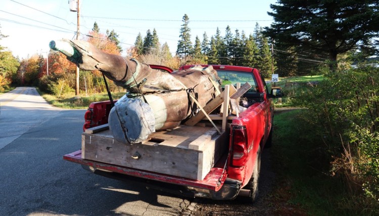 The Coke bottle statue is cradled up in late October. Island craftsman Dave Moyer will work to restore the sculpture this winter in his island workshop.