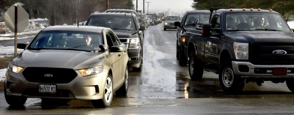 As students and staff leave Skowhegan Area High School on Monday, state police Det. Bryant Jacques, in unmarked cruiser at left, also leaves the school grounds following a posted threat to the school. "I did some drive-through passes at the school today to let students know we (law enforcement) are present," Jacques said.