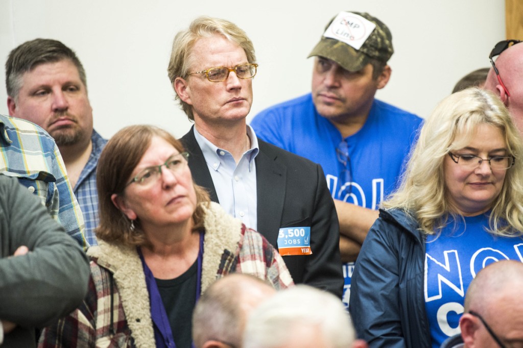 Ben Dudley, left center, director of Mainers for Clean Jobs, listens to comments made to Somerset County commissioners Wednesday about the pros and cons of the proposed CMP power line through parts of Somerset County.