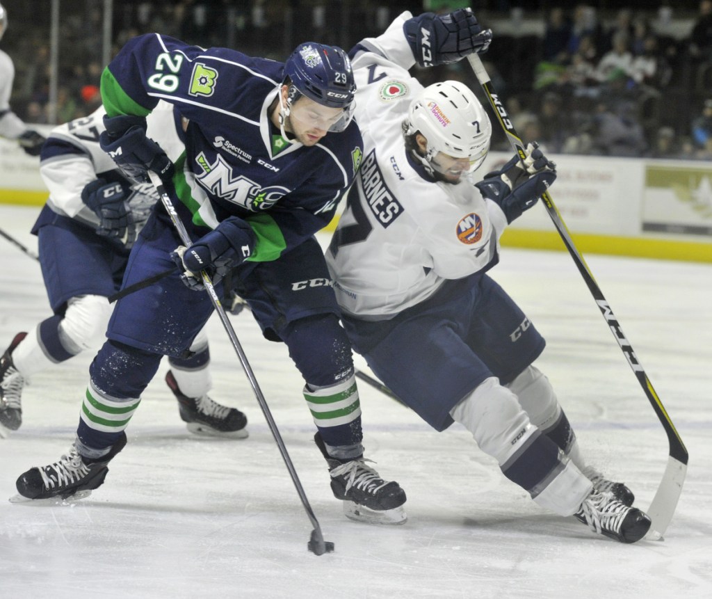 Mariners defenseman Garrett Cecere pulls the puck away from Worcester's Tyler Barnes during a rush up ice leading to Maine's first-period goal Sunday.